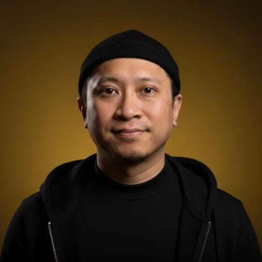 Nazreen Daud in a black beanie against a gold backdrop