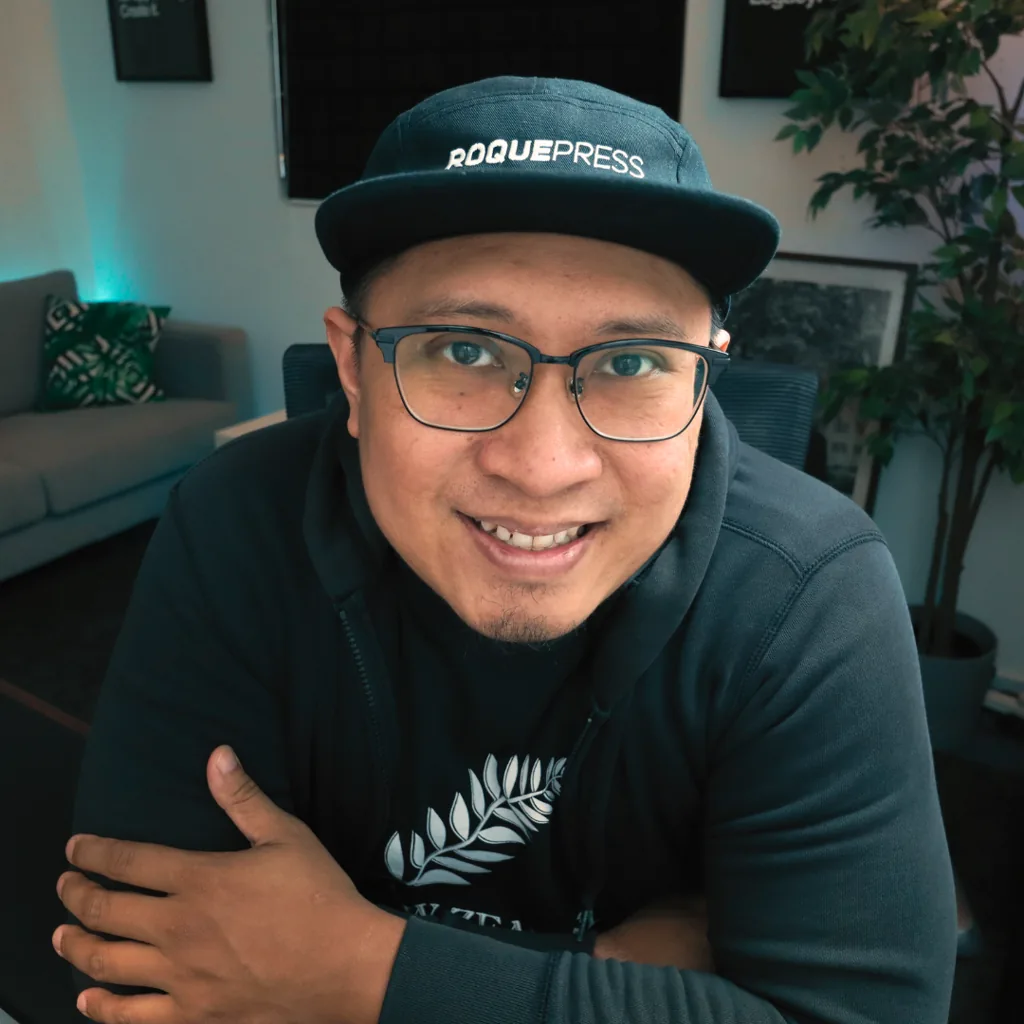 Nazreen Daud wearing a Roquepress cap and glasses at his desk