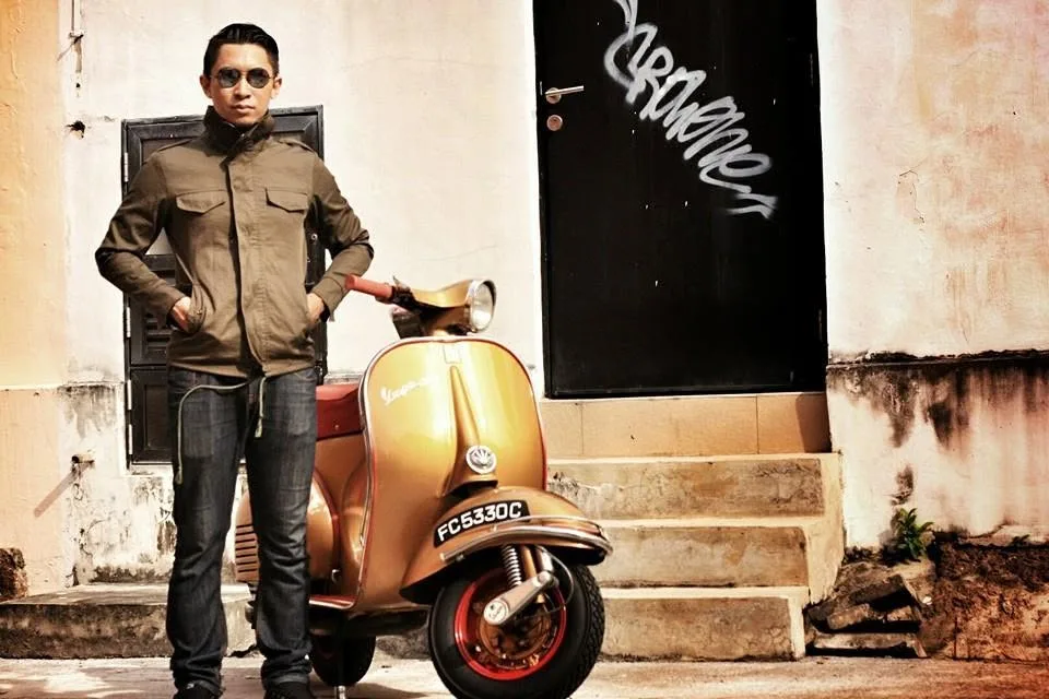 Nazreen Daud standing beside his first Vespa, painted Iron Man-inspired gold with a red seat